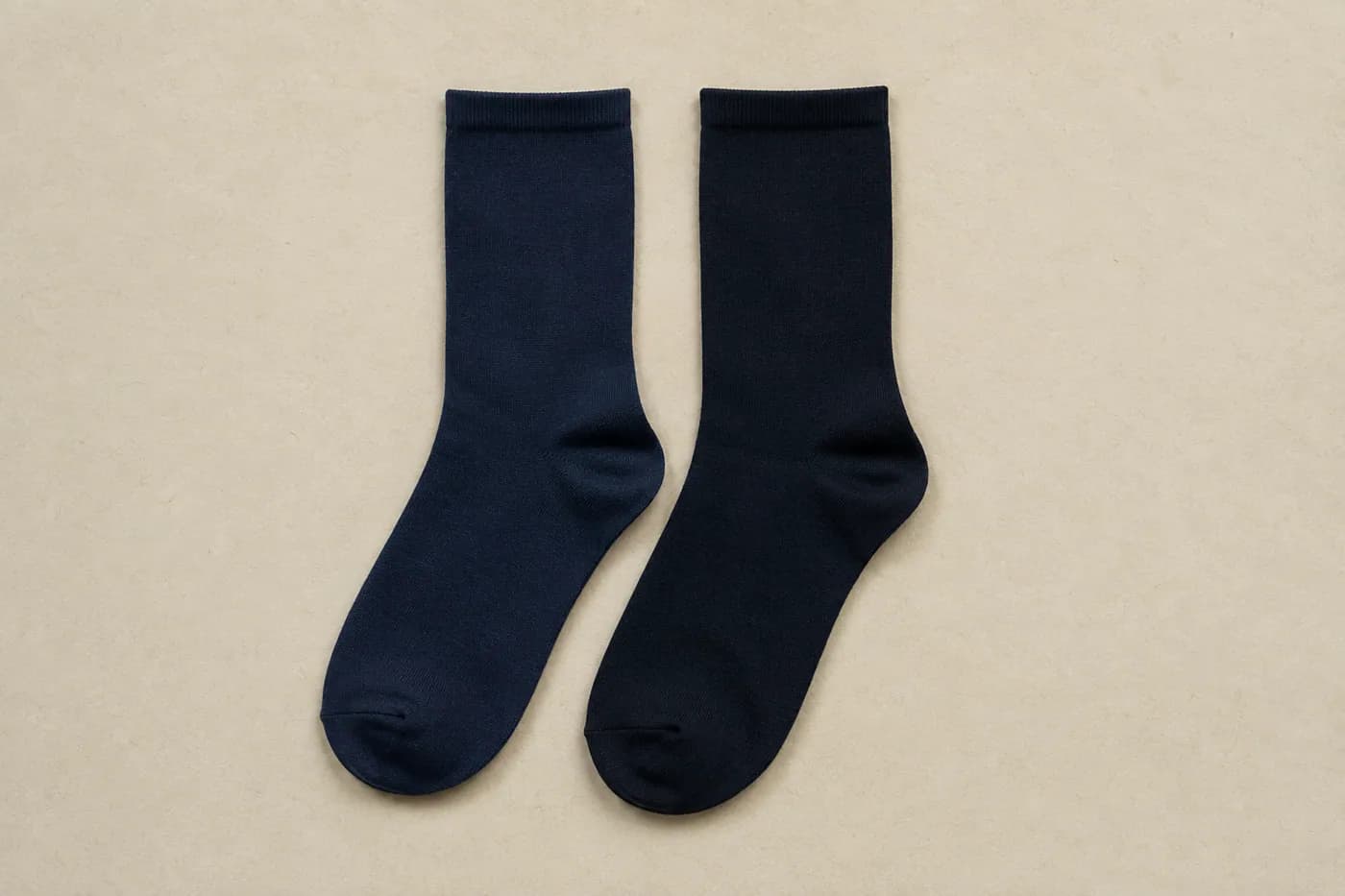 Two plain socks side by side, one navy and one very slightly darker ink blue